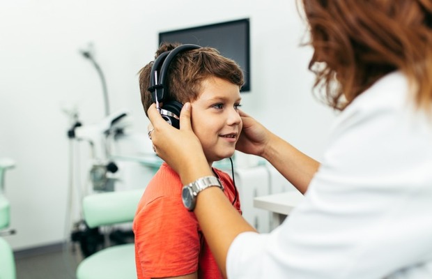 Healthcare professional completing a hearing exam on a infant.